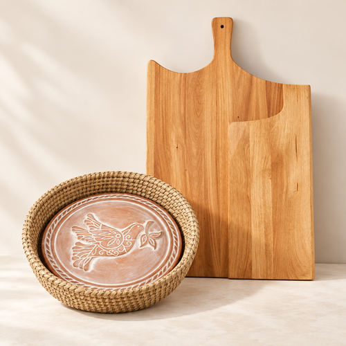 Artisan Kitchen gift set with one large wooden cutting board and Peace Dove bread warmer in woven basket