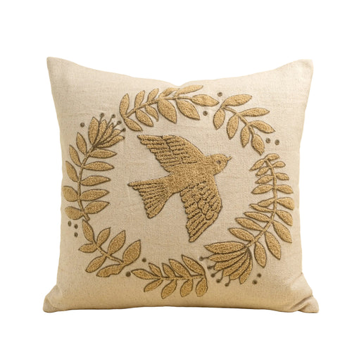 Decorative pillow with embroidered bird and leaves on a beige background
