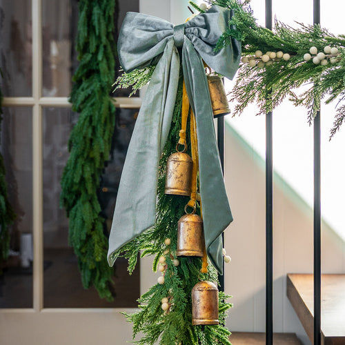 GP Home holiday styling: sage velvet bow and bell cascade.