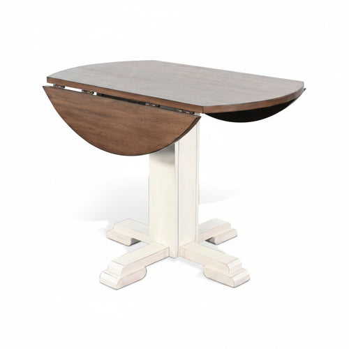 A Pasadena Drop Leaf Table with a stained buckskin top and a marble white base, featuring a round shape and drop leaves on a central pedestal base.